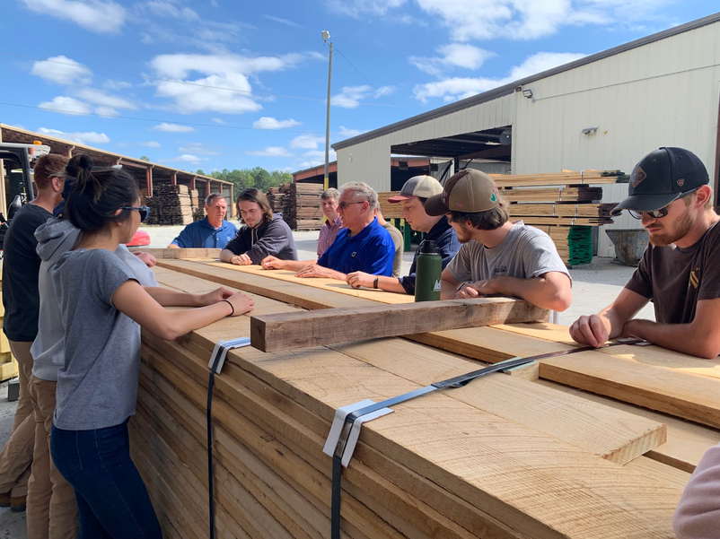 Wood Science and Technology students in discussion at lumber yard.